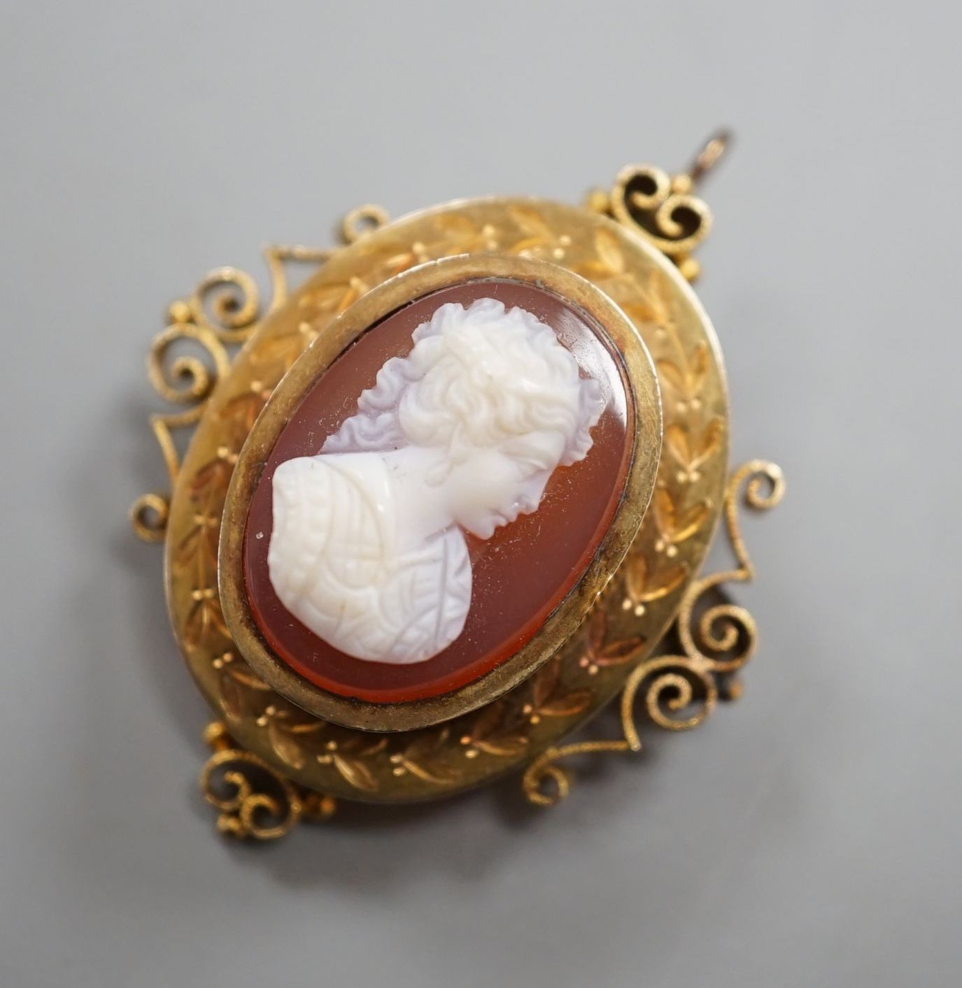 A Victorian style yellow metal and hardstone cameo set oval hardstone pendant brooch, 37mm, gross 6.9 grams.